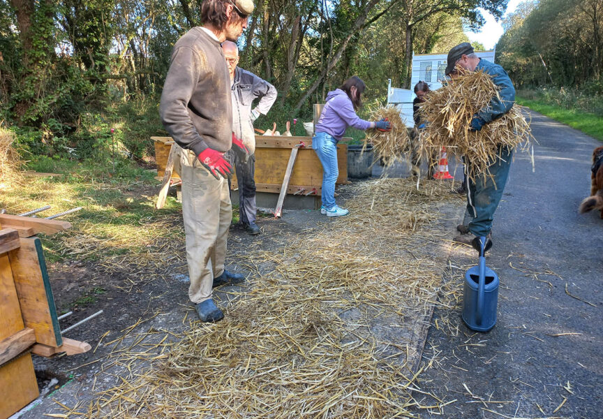 Des bénévoles construisent des murets en bauge sur la route des Landes.