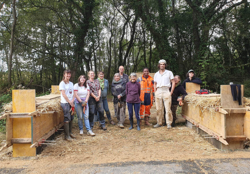 Des bénévoles construisent des murets en bauge sur la route des Landes.