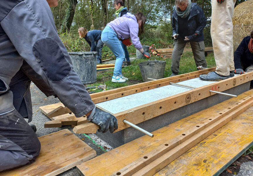 Des bénévoles construisent des murets en bauge sur la route des Landes.