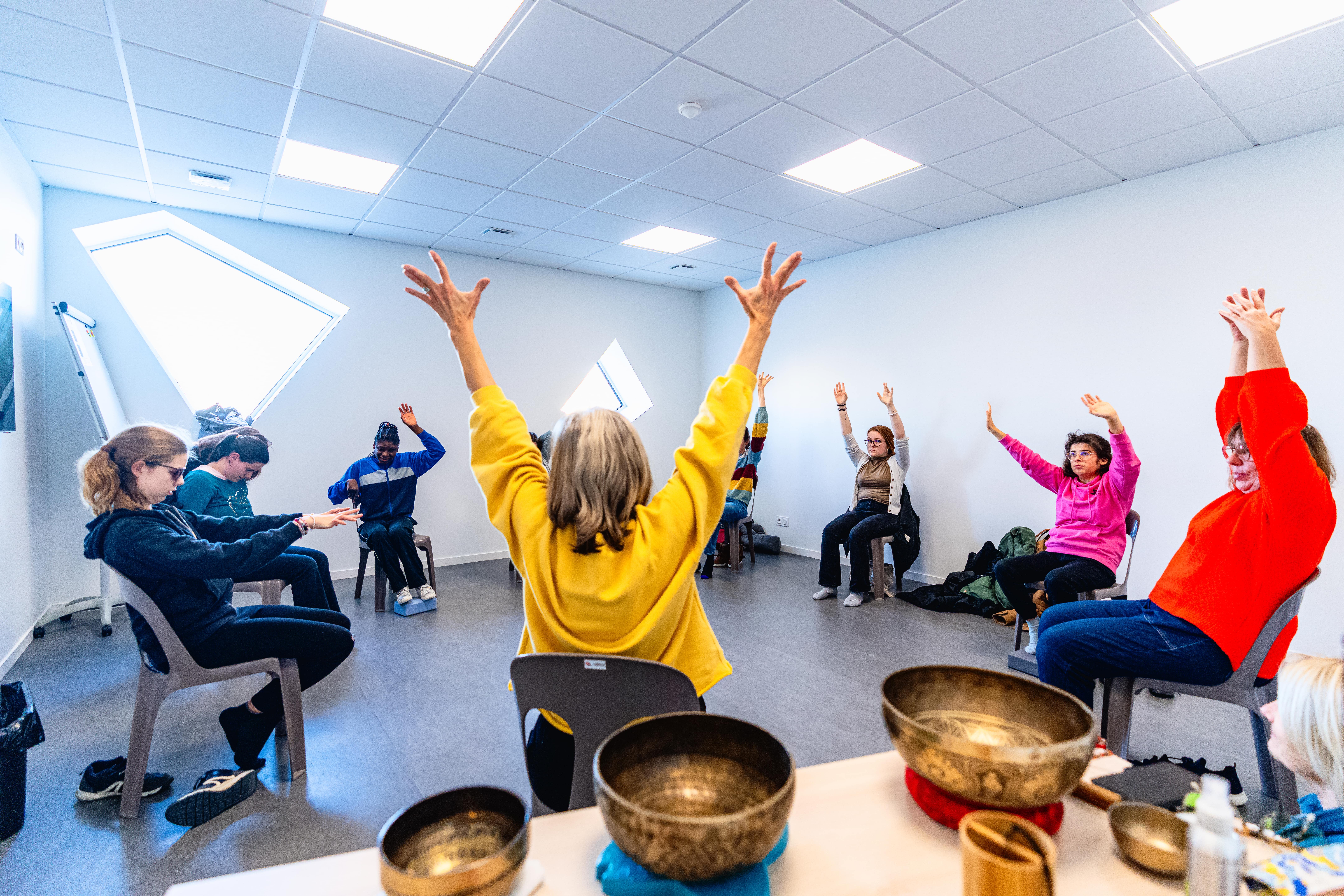 huit personnes font du yoga sur chaise.